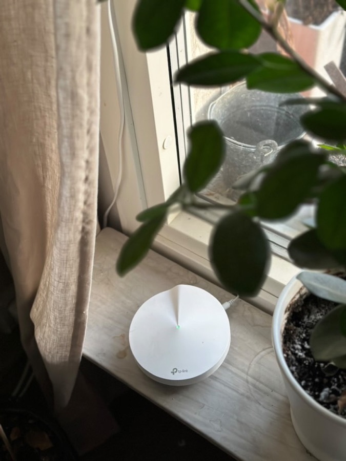 En TP-Link Deco mesh-nod placerad i ett fönster
